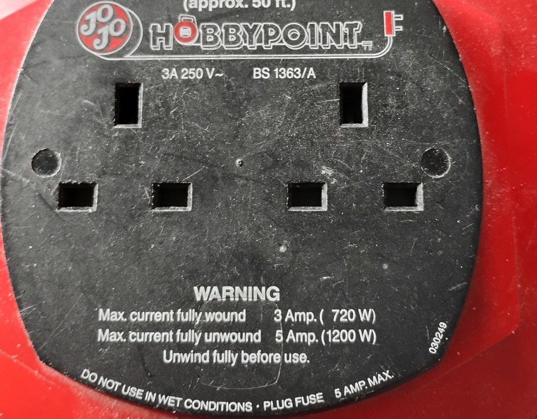 close-up of UK-style reel extension lead faceplate showing different current capacities depending on if the lead is unwound or wound when in use
